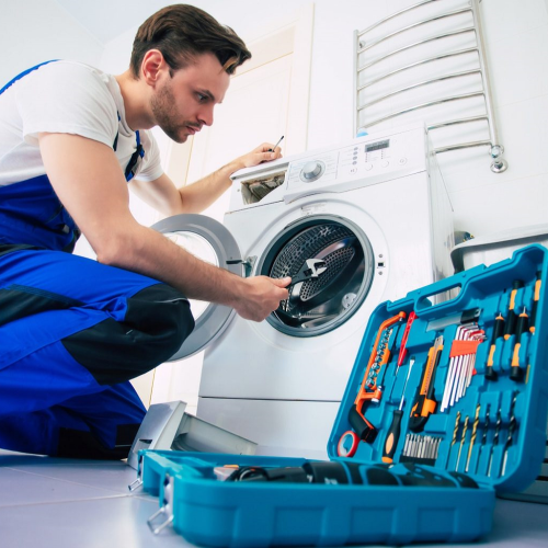 Technician repairing a washing machine in a Folsom, CA home.